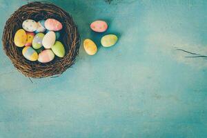 vistoso Pascua de Resurrección huevo en el nido en azul pastel color madera antecedentes con espacio. foto