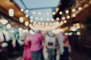 blurred night market festival people walking on road photo