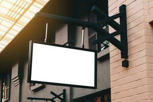 Empty signage and blank mock up hanging on street with copy space photo