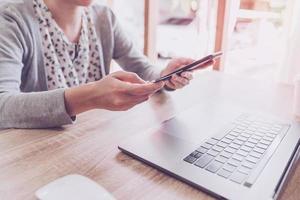 woman using smart phone and credit card for shopping online in coffee shop photo