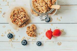 Homemade granola bar and fresh berries on wood table with space. photo