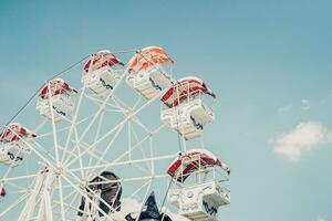 Ferris wheel on cloudy sky background with vintage toned. photo