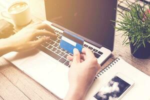 Man holding credit card and using laptop. Online payment. photo