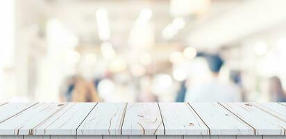 Empty wood table and blurred light table in shopping mall with bokeh background. product display template. photo