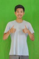 expressive casual Balinese Asian guy model for advertising with green screen studio background photo