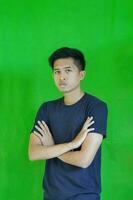 expressive casual Balinese Asian guy model for advertising with green screen studio background photo