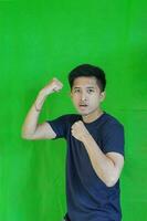 expressive casual Balinese Asian guy model for advertising with green screen studio background photo