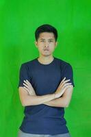 expressive casual Balinese Asian guy model for advertising with green screen studio background photo