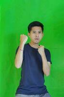 expressive casual Balinese Asian guy model for advertising with green screen studio background photo