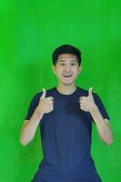 expressive casual Balinese Asian guy model for advertising with green screen studio background photo