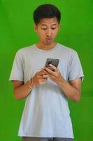 expressive casual Balinese Asian guy model for advertising with green screen studio background photo