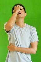 expressive casual Balinese Asian guy model for advertising with green screen studio background photo
