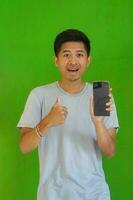 expressive casual Balinese Asian guy model for advertising with green screen studio background photo