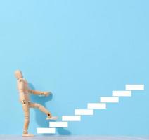 A wooden mannequin and drawn steps going up, a concept of achieving a goal, strong personality photo
