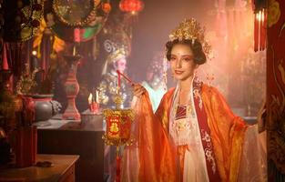retrato de un chino mujer con un mano linterna en sagrado santuarios o templos, y en chino dónde mano lámpara media bueno suerte y felicidad foto