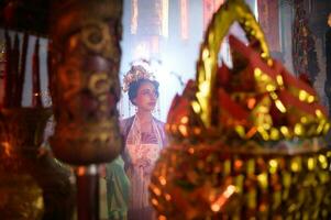 chino mujer hacer deseos, orar, y ligero velas en el ocasión de el anual chino nuevo año festival, en un venerado santuario o templo foto