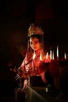 chino mujer hacer deseos, orar, y ligero velas en el ocasión de el anual chino nuevo año festival, en un venerado santuario o templo
