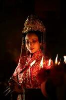 Chinese woman make wishes, pray, and light candles. On the occasion of the annual Chinese New Year festival, in a revered shrine or temple photo