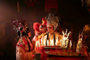 Male and female Chinese opera actors Light a candle to pray homage to the gods to enhance the prosperity for yourself on the occasion photo