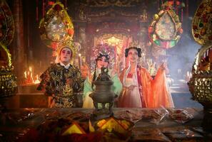 Male and female Chinese opera actors Light a candle to pray homage to the gods to enhance the prosperity for yourself on the occasion photo