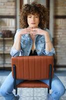 Stylish woman sitting on chair in loft style room photo