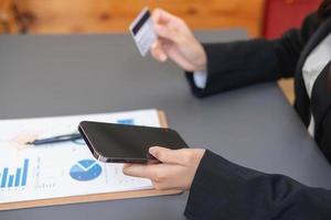 Young Asian woman shopping online using a credit card. for online payment within the house credit card payment concept photo