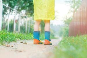 child in rubber boots walking outdoor. child's feet in a rubber boot photo