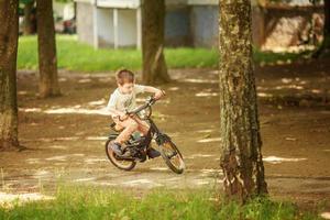 the boy is riding a bike on the street photo