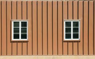 fachada de dos ventanas en marrón envase pared foto