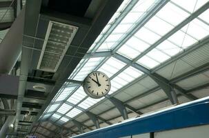 Public clock in sky train station with cctv. photo