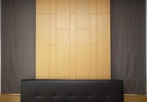 Brown leather headboard decorated with wooden wall and brown curtain. photo