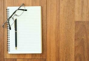 Eyeglasse and notepad on wood deck photo