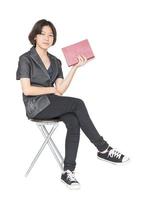mujer leyendo un libro sentado en una silla foto