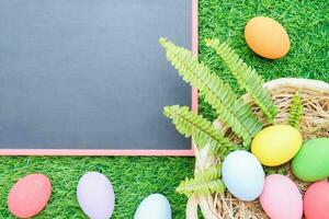 Close up Easter eggs on grass and blackboard mockup photo