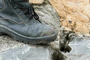 Trekking leather boot on the rock photo