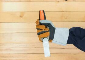 Hand in glove holding chisel photo