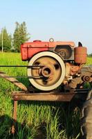 The old red water pump that is spinning at full power to pump water into the rice fields of farmers during the rice growing season in rural Thailand.