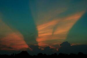 atmosphere in the evening sky as the sun sets - beams - of the sun and clouds create beautiful colors and many colors, creating a warm and romantic atmosphere on a summer evening. photo