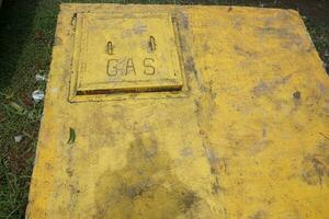 Yellow sign that there is a gas pipe embedded underground photo