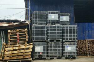 Piles of wooden pallets and liquid storage boxes photo