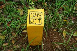 Yellow sign that there is a gas pipe embedded underground photo