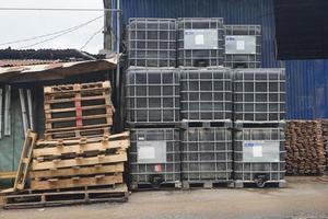 Piles of wooden pallets and liquid storage boxes photo