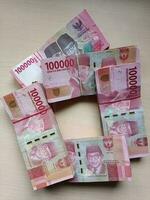 pile of 100 thousand rupiah denominations photo