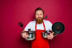 infeliz cocinero con barba y rojo delantal es Listo a cocinar foto