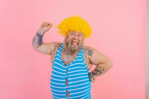Happy man with yellow wig and swimsuit is ready to the summer photo