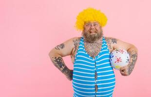 Fat happy man with beard and wig play with the ball photo