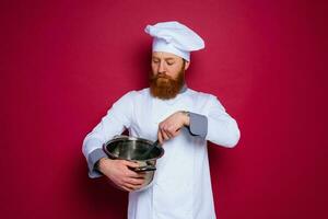 serious chef with beard and red apron is ready to cook photo