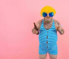 Fat man with beard and wig smokes cigarettes and drinks beer photo