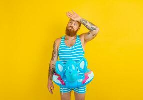 man with inflatable donut with elephant is ready to swim photo