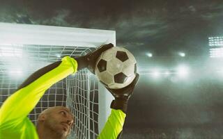 Close up of a soccer goalkeeper saving the ball at the corner of the goalposts photo